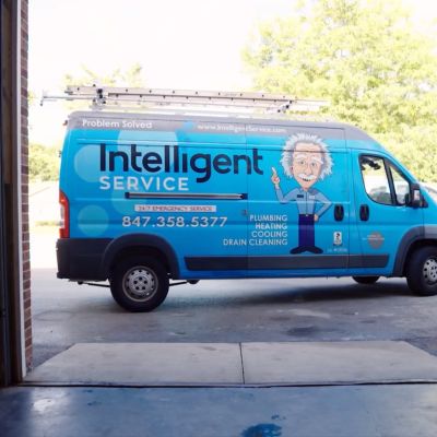 Blue Intelligent Service van for plumbing, heating, cooling, and drain cleaning, parked outside garage.
