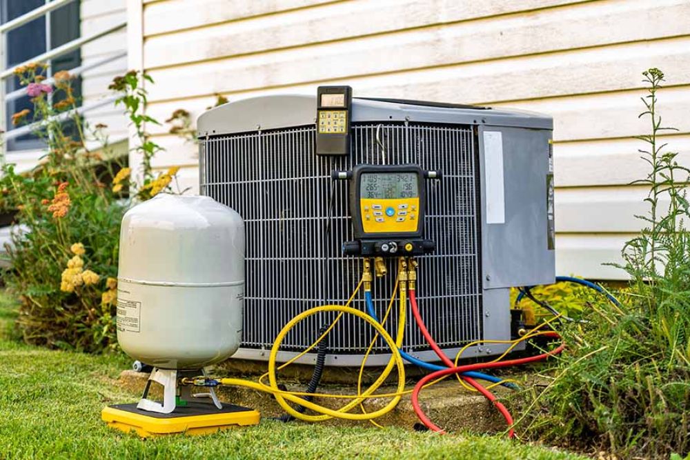 HVAC unit maintenance with gauges and tank outside a house. Heating and cooling system repair concept.
