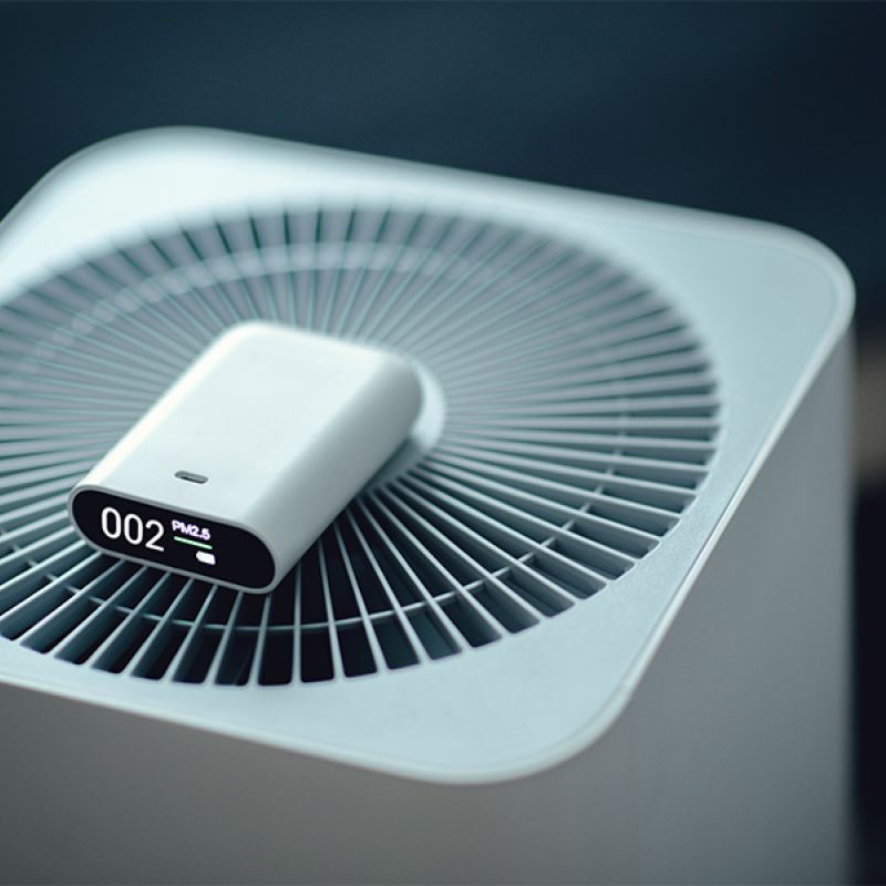 Modern air purifier with digital PM2.5 display screen for monitoring air quality indoors.