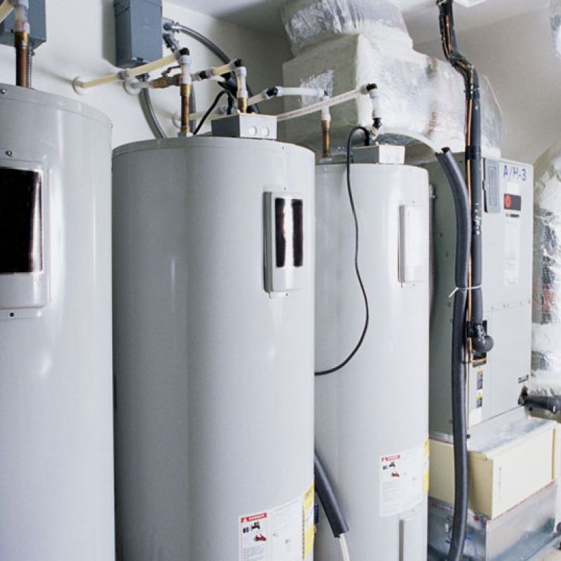 Industrial water heaters and duct system in a utility room, showcasing efficiency and modern HVAC setup.