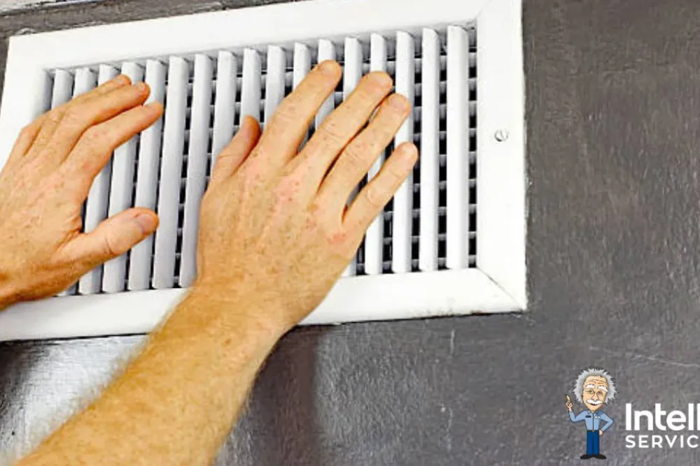 Hand adjusting water heater connections for maintenance in a tiled bathroom. Intelligent Service logo visible.