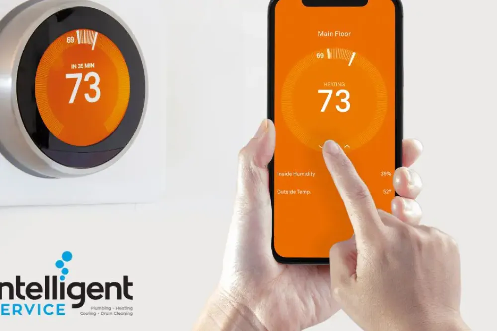 Smart thermostat being controlled via smartphone app, displaying 73 degrees. Intelligent Service HVAC logo visible.