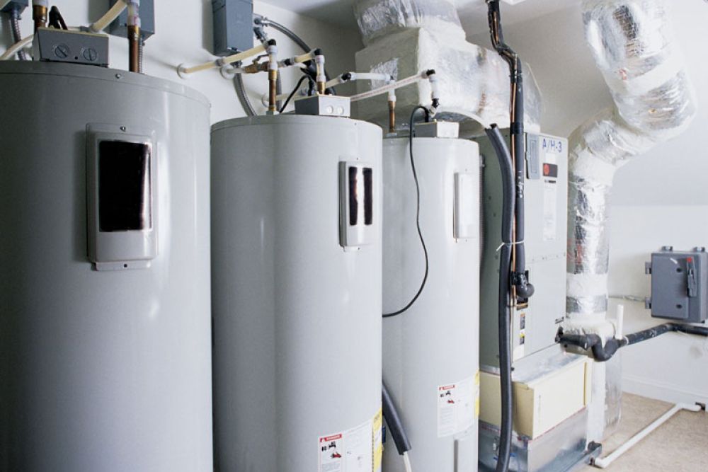 Industrial water heaters and duct system in a utility room, showcasing efficiency and modern HVAC setup.