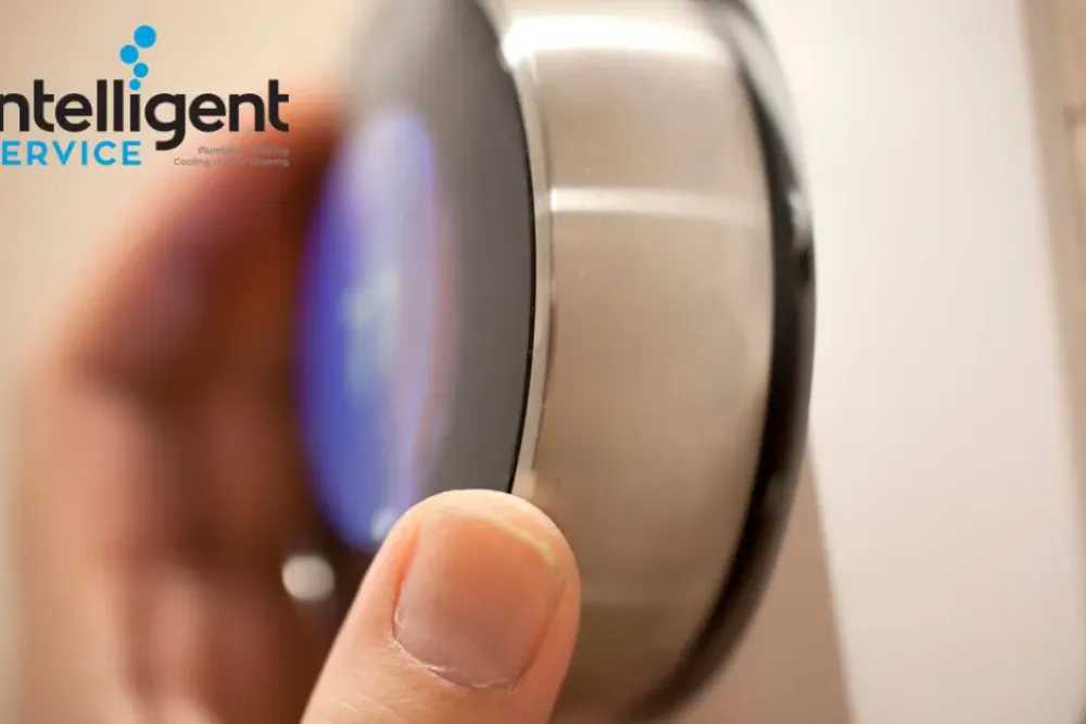 Hand adjusting a smart thermostat with Intelligent Service logo for heating and cooling solutions.